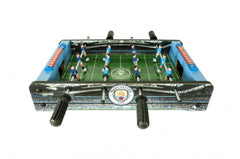Manchester City FC 20 inch Football Table Game LKT Sport Table top, football game in a stadium and pitch design 6 players per team in sky or royal blue Sturdy construction with grass effect printed pitch A score indicator on each side Complete with two pl