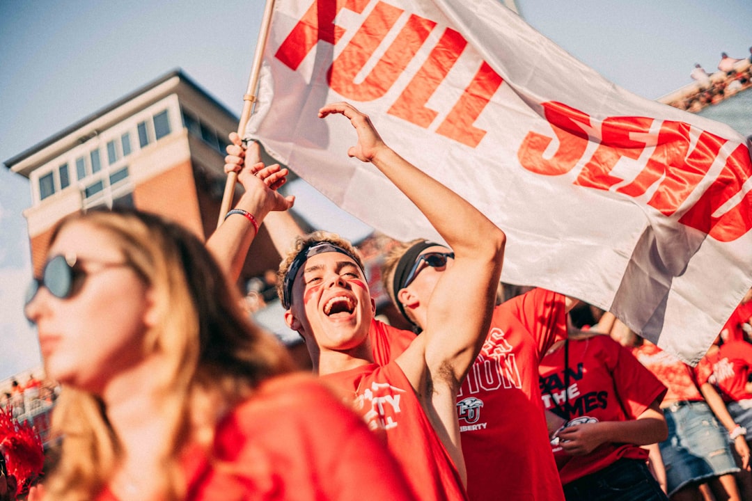 Cheering fans at a football game, celebrating the impact of English Premier League on local communities.