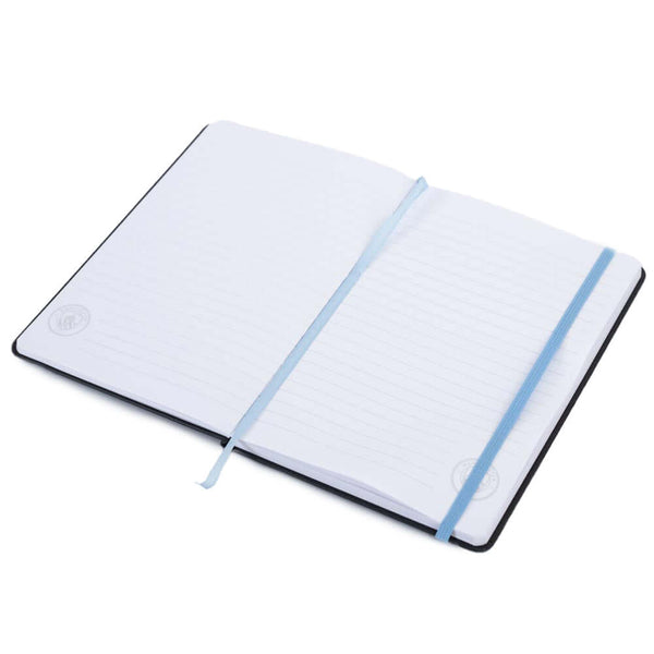 Manchester City FC Classic Notebook LKT Sport Premium black faux leather hardback notebook with a sky blue embossed Man City CrestRuled pages featuring a Man City crest and a handy bookmarkComplete with an elastic closureOfficial licensed productApprox 14