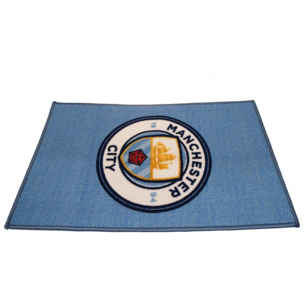 Manchester City FC Rug LKT Sport Bright colourful bedroom rug featuring a large central club crest Made from 100% polyamide with a non-slip backing Machine washable Official licensed product Approx 80cm x 50cm On a header card Rugs