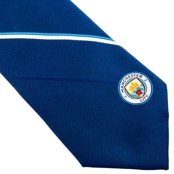 Manchester City FC Stripe Tie LKT Sport Navy blue and white striped tie featuring a small City crest to the bottomIncludes an embroidered crest on the reverse100% polyesterOfficial licensed productApprox 148cm x 8cm Neckties