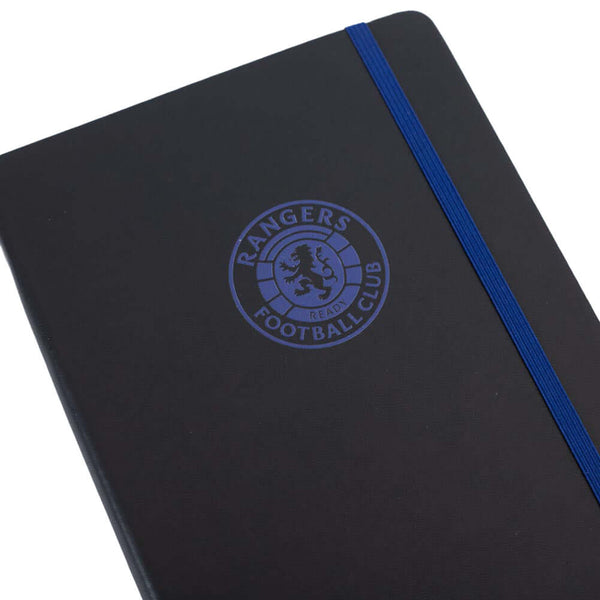 Rangers FC Classic Notebook LKT Sport Premium black faux leather hardback notebook with a royal blue embossed Rangers CrestRuled pages featuring a Rangers crest and a handy bookmarkComplete with an elastic closureOfficial licensed productApprox 14cm x 21c
